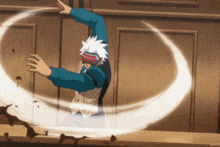 a man in a blue shirt and a red and white headband is spinning in a circle with his arms outstretched