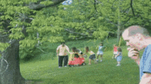 a blurred image of people playing in a park with trees in the background