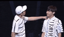 two young men are standing next to each other on a stage .