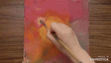 a person is painting on a piece of paper with the words made in animotica below them