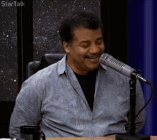 a man sitting in front of a microphone with startalk written on the bottom of the screen