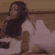 a woman is wearing headphones and holding a microphone in her hand .