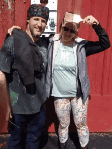 a woman wearing a shirt that says hardkill stands next to a man with his arm around her shoulder