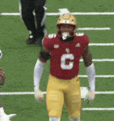 a football player wearing a red jersey with the number 6 on it is standing on the field .