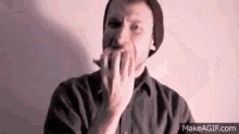a man with a beard is eating an apple with his hands .