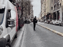 a man walking down a street with a white van that says ' a ' on the side