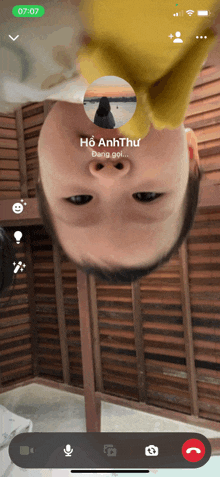 a phone screen shows a video call with ho anh thu on the screen