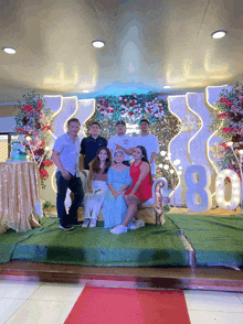 a group of people posing for a picture in front of a sign that says ' 80 '