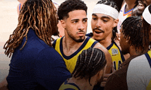 a group of basketball players are huddled together with one wearing a jersey with the number 14 on it
