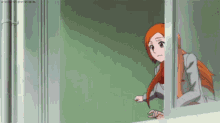 a girl with long orange hair is looking out a window