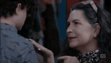 a woman is giving a fist bump to a boy in a movie .
