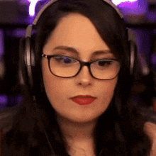 a woman wearing glasses and headphones is making a funny face .
