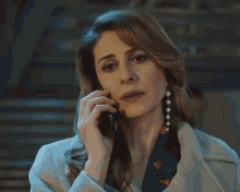 a woman in a coat is talking on a cellphone