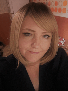 a woman with blonde hair and blue eyes looks at the camera