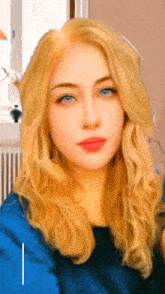 a woman with long blonde hair and blue eyes is taking a selfie
