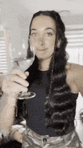 a woman holds a glass of wine in her hand