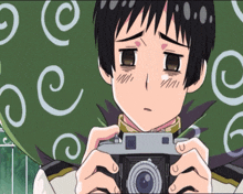 a boy is holding a camera in front of a green background with white swirls