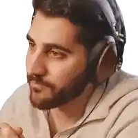 a man with a beard wearing headphones looks to his left
