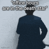 a man in a suit is standing in front of a wall with the words " office hours are in the death star " written on it
