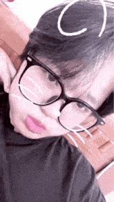 a close up of a person wearing glasses and a black shirt .