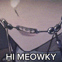 a close up of a person 's face with a necklace and the words `` hi meowky '' written on it .