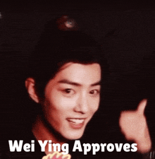 a man giving a thumbs up with the words wei ying approves behind him