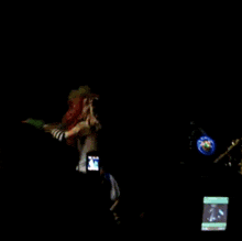 a woman with dreadlocks is dancing on a stage in front of a screen that says j.