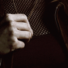 a person is holding a necklace with a pentagram pendant