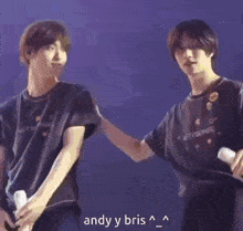 two young men are standing next to each other on a stage .