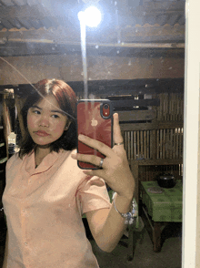 a girl taking a picture of herself with her iphone