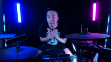 a man playing drums with his eyes closed and a shirt with the number 5 on it