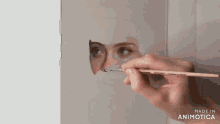 a person is painting a picture of a woman 's face with a brush .