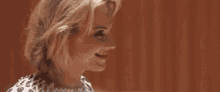 a close up of a woman 's face smiling and looking down