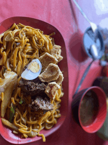a close up of a plate of noodles with a hard boiled egg on top