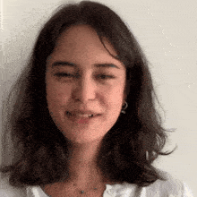 a close up of a woman 's face with a white shirt and a necklace .