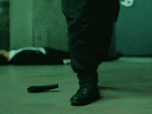 a man in a suit is laying on the ground while a man in a suit is walking away