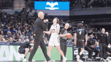 a basketball player with the number 12 on his jersey is being yelled at by a referee