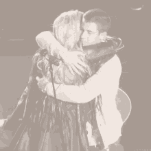 a black and white photo of a man and a woman hugging with the word lovanas on the bottom