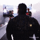 a man wearing a jacket that says ' tiffany luv24 ' on the bottom