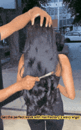 a woman with long black hair is being combed by a man with the words get the perfect wave with hairfactory 's wavy wig