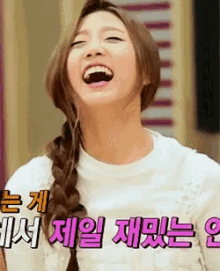 a woman with braided hair is laughing in front of a sign with chinese writing