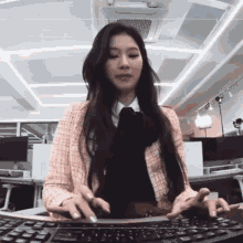 a woman with long hair is typing on a computer keyboard
