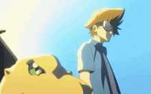 a man wearing a straw hat and sunglasses stands next to a yellow monster