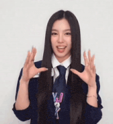 a girl in a suit and tie is making a heart with her hands