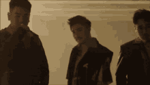 three men are standing next to each other and one of them has a beard