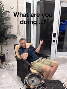 a man sitting in a chair with the words what are you doing written above him