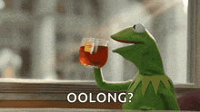 kermit the frog is holding a cup of lipton tea