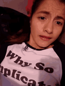 a woman wearing a white shirt that says why so complicated