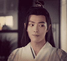 a young man with long hair is wearing a white kimono