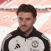 a man is wearing a manchester united jacket